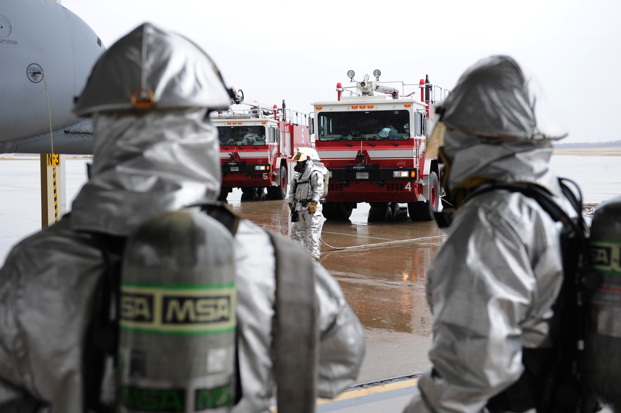 Firefighters from the 509th Civil Engineer Squadron prepare to evacuate a patient during egress training at Whiteman Air Force Base, Mo., March 18, 2015. Egress training provides firefighters with practice responding to disabled aircraft or injured aircrew so they are familiar with how to safely respond to aircraft mishaps. (U.S. Air Force photo by Airman 1st Class Joel Pfiester/Released)