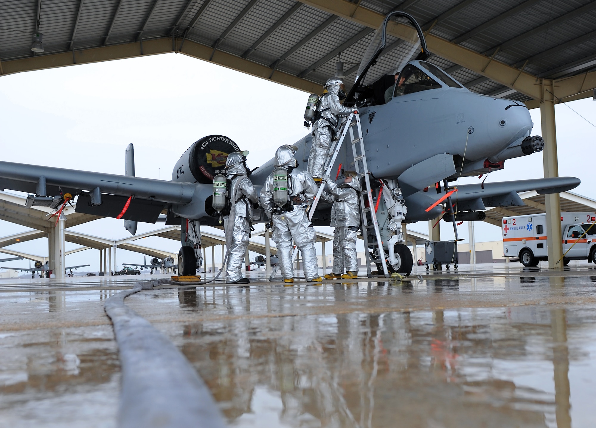 Firefighters from the 509th Civil Engineer Squadron evacuate a simulated patient during egress training at Whiteman Air Force Base, Mo., March 18, 2015. Egress training provides firefighters with practice responding to disabled aircraft or injured aircrew so they are familiar with how to safely respond to aircraft mishaps. (U.S. Air Force photo by Airman 1st Class Joel Pfiester/Released)