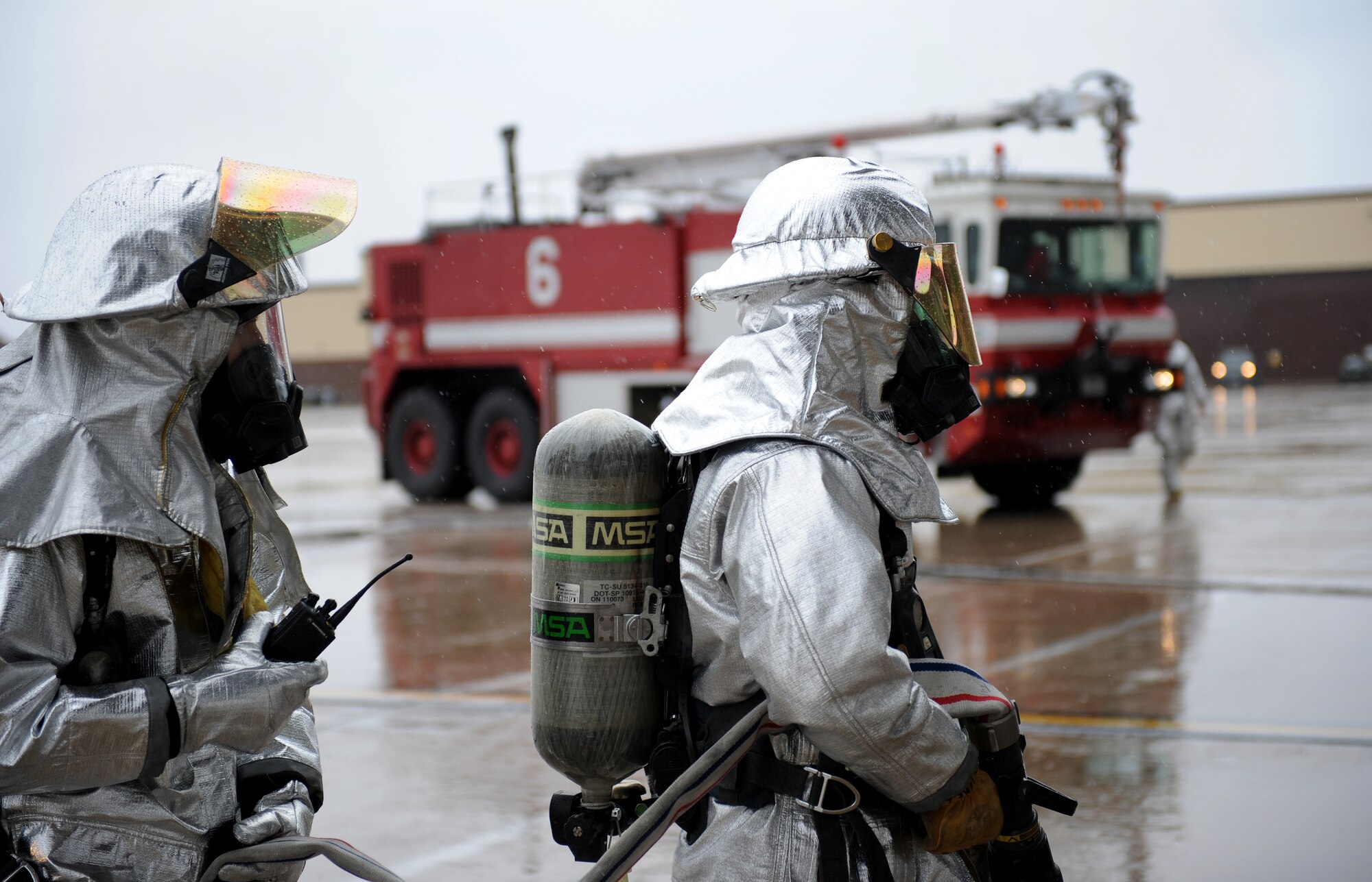 Firefighters from the 509th Civil Engineer Squadron prepare to evacuate a simulated patient during egress training at Whiteman Air Force Base, Mo., March 18, 2015. Before evacuating the patient, the firefighters must extinguish any flames that may be present on the aircraft. (U.S. Air Force photo by Airman 1st Class Joel Pfiester/Released)
