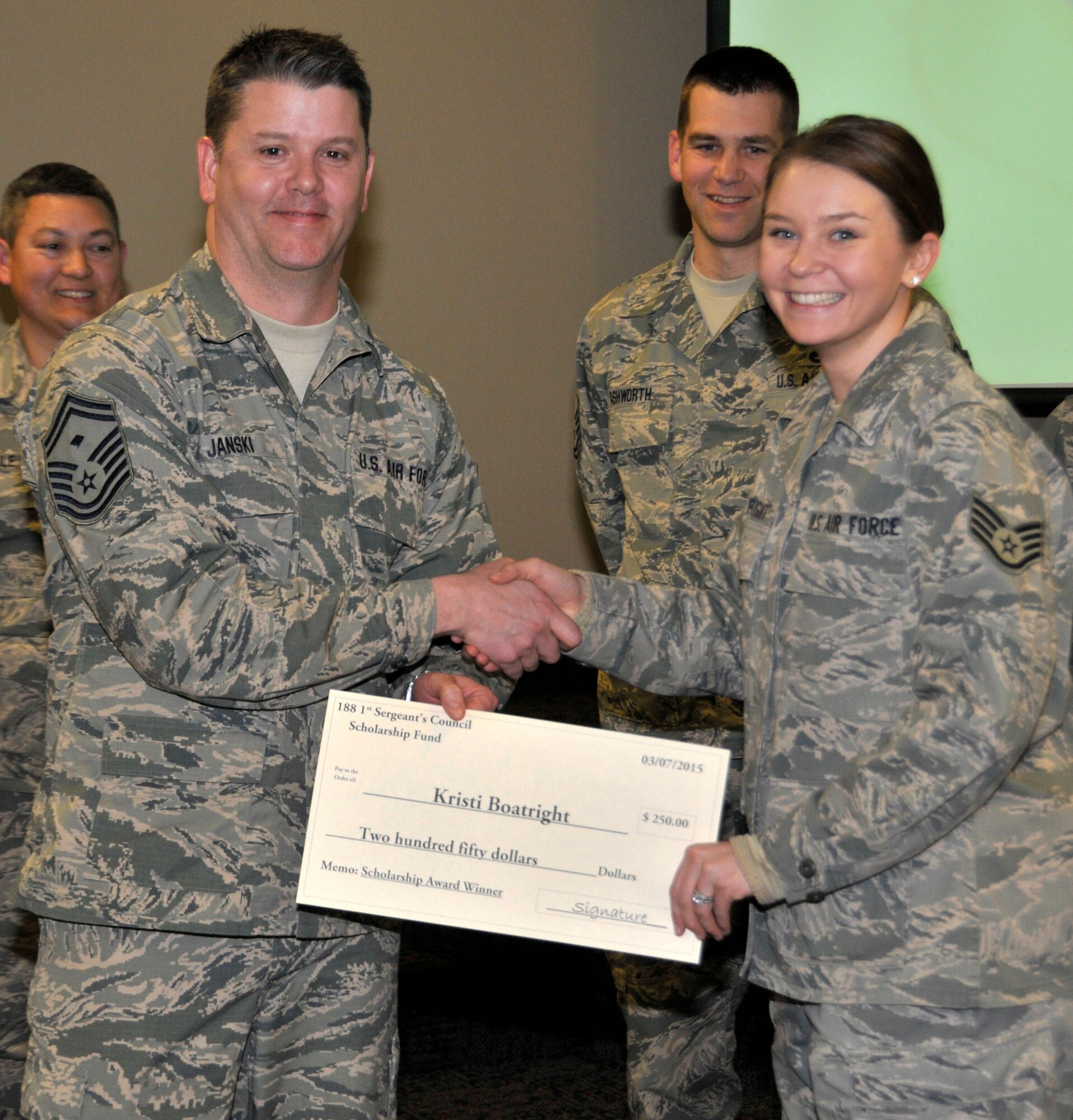 Staff Sgt. Kristi Boatright of the 188th Civil Engineer Squadron accepts the 188th Wing First Sergeant Council Scholarship from Senior Master Sgt. Sam Janski at Ebbing Air National Guard Base, Fort Smith, Ark., March 7, 2015. Boatright is currently attending the University of Arkansas at Little Rock, and is majoring in liberal arts. Boatright also plans to pursue a master’s degree in social work. The scholarship awarded to Boatright totaled $250. (U.S. Air National Guard photo by Staff Sgt. John Suleski/released)