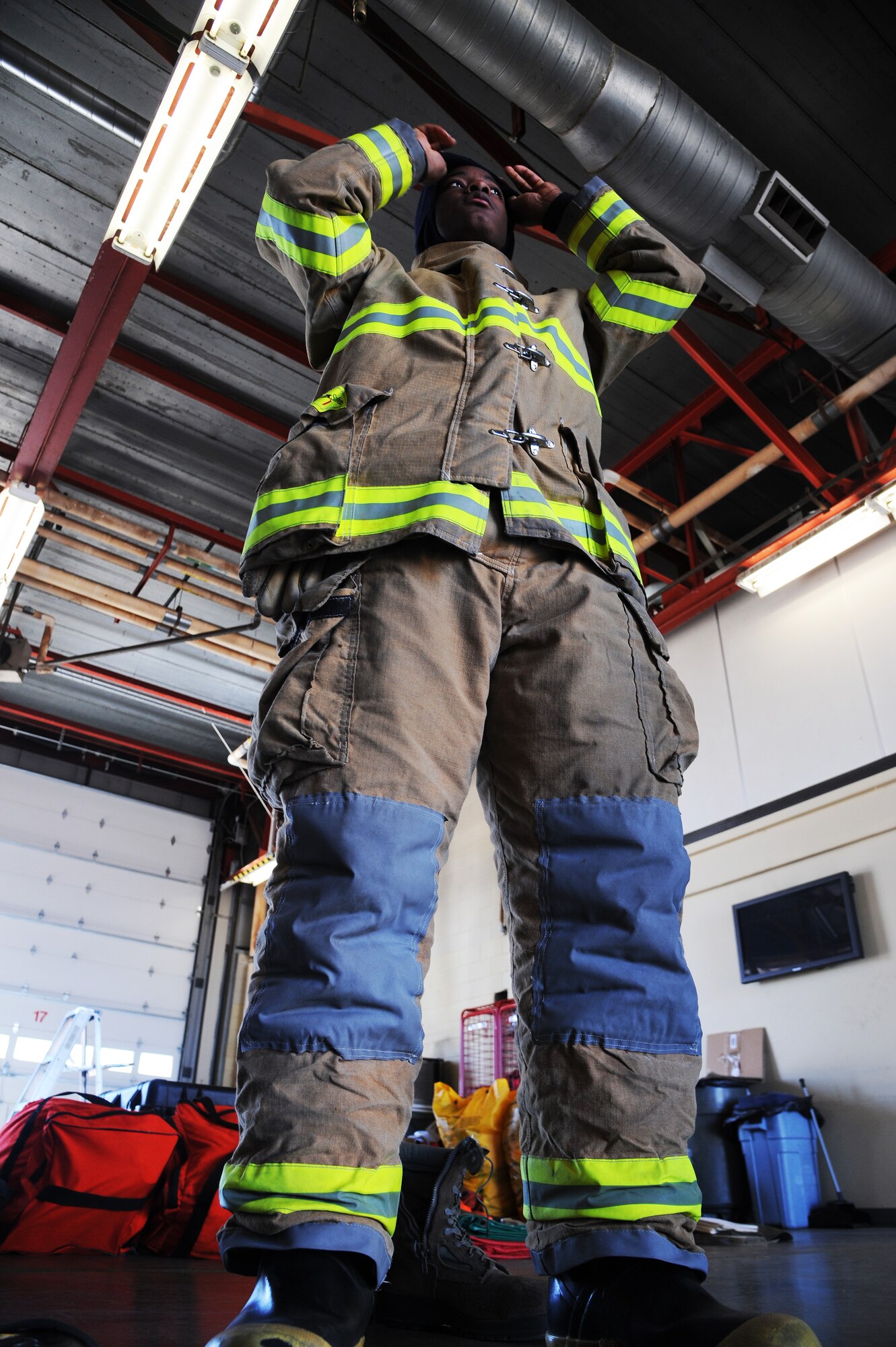 U.S. Air Force Senior Airman Cory Barrett, 509th Civil Engineer Squadron firefighter, suits up for a bunker drill exercise at Whiteman Air Force Base, Mo., March 30, 2015. Recently, Barrett assisted a victim of a vehicle accident while off duty in Warrensburg, Mo.  (U.S. Air Force photo by Senior Airman Keenan Berry/Released) 