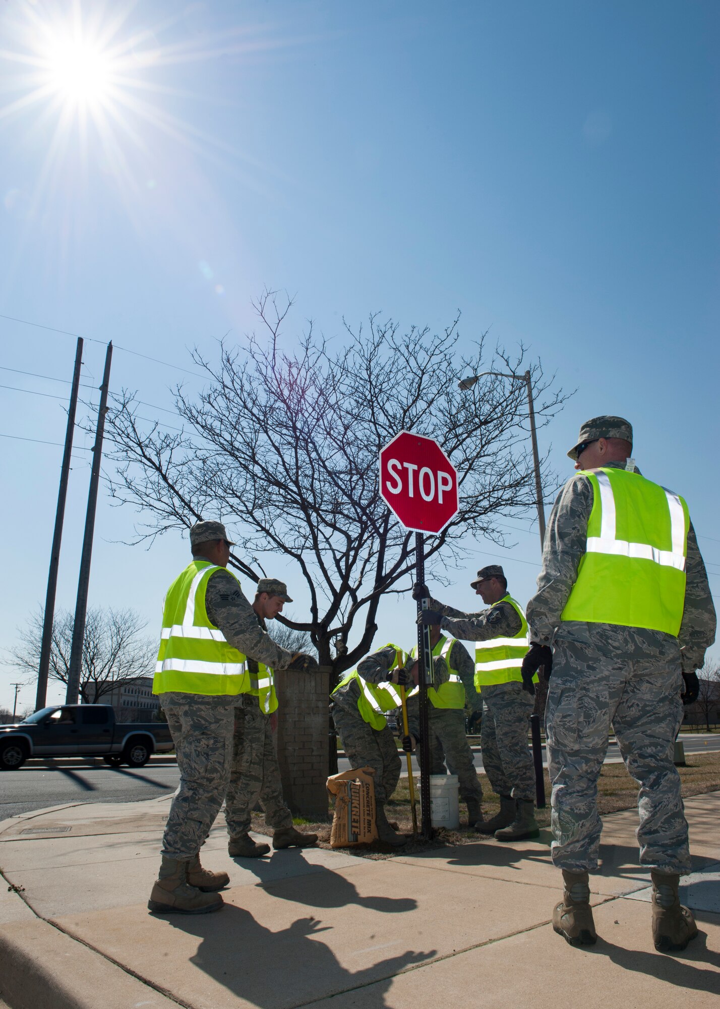 Col. Michael Grismer, 436th Airlift Wing commander, Chief Master Sgt. Stanley Cadell, 436th AW command chief, and Airmen from the 436th Civil Engineer Squadron structures and heavy repairs shops, replace stop signs April 1, 2015, at Dover Air Force Base, Del. Wing leadership got their hands dirty by working with the Airmen. (U.S. Air Force photo/Airman 1st Class Zachary Cacicia)
