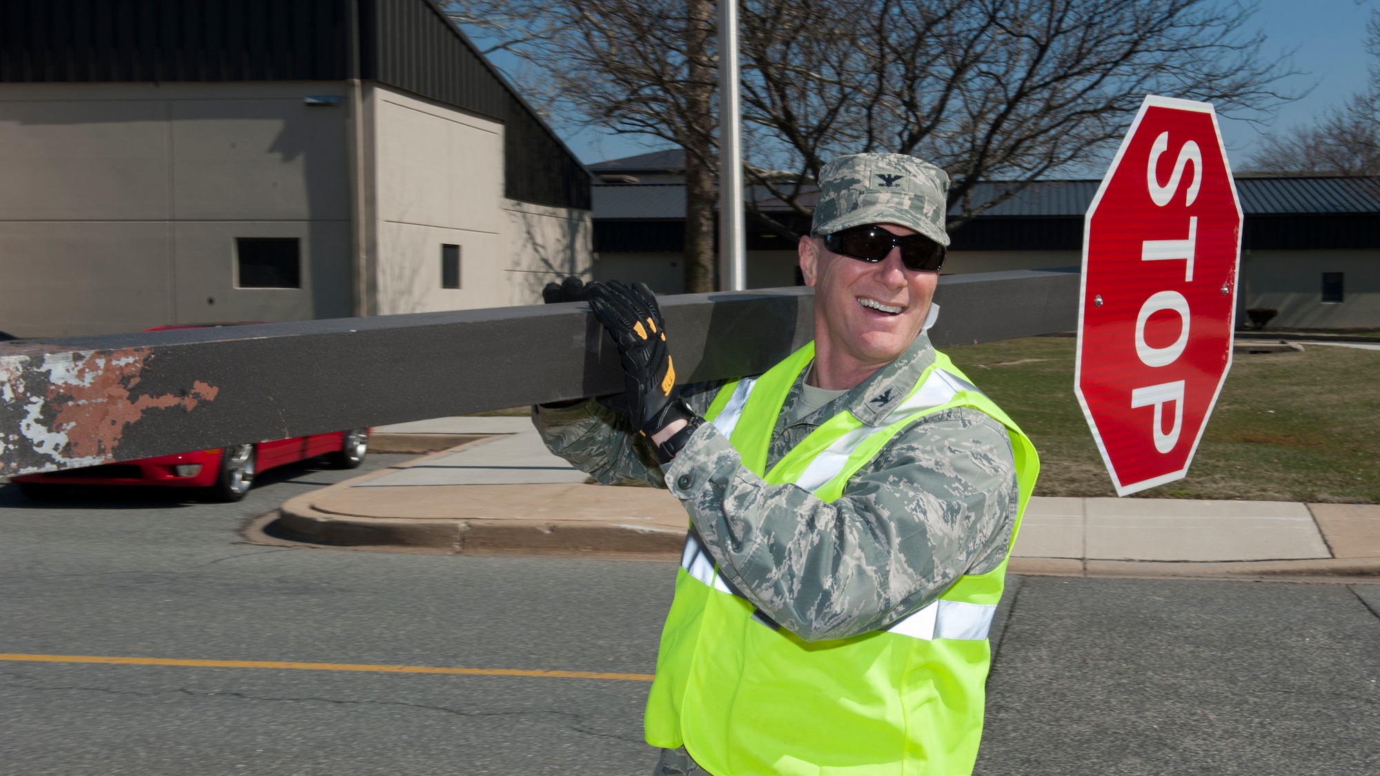 Col. Michael Grismer, 436th Airlift Wing commander, carries an old stop sign that he helped replace April 1, 2015, at Dover Air Force Base, Del. Grismer spent time doing some hands-on work with Team Dover Airmen. (U.S. Air Force photo/Airman 1st Class Zachary Cacicia)