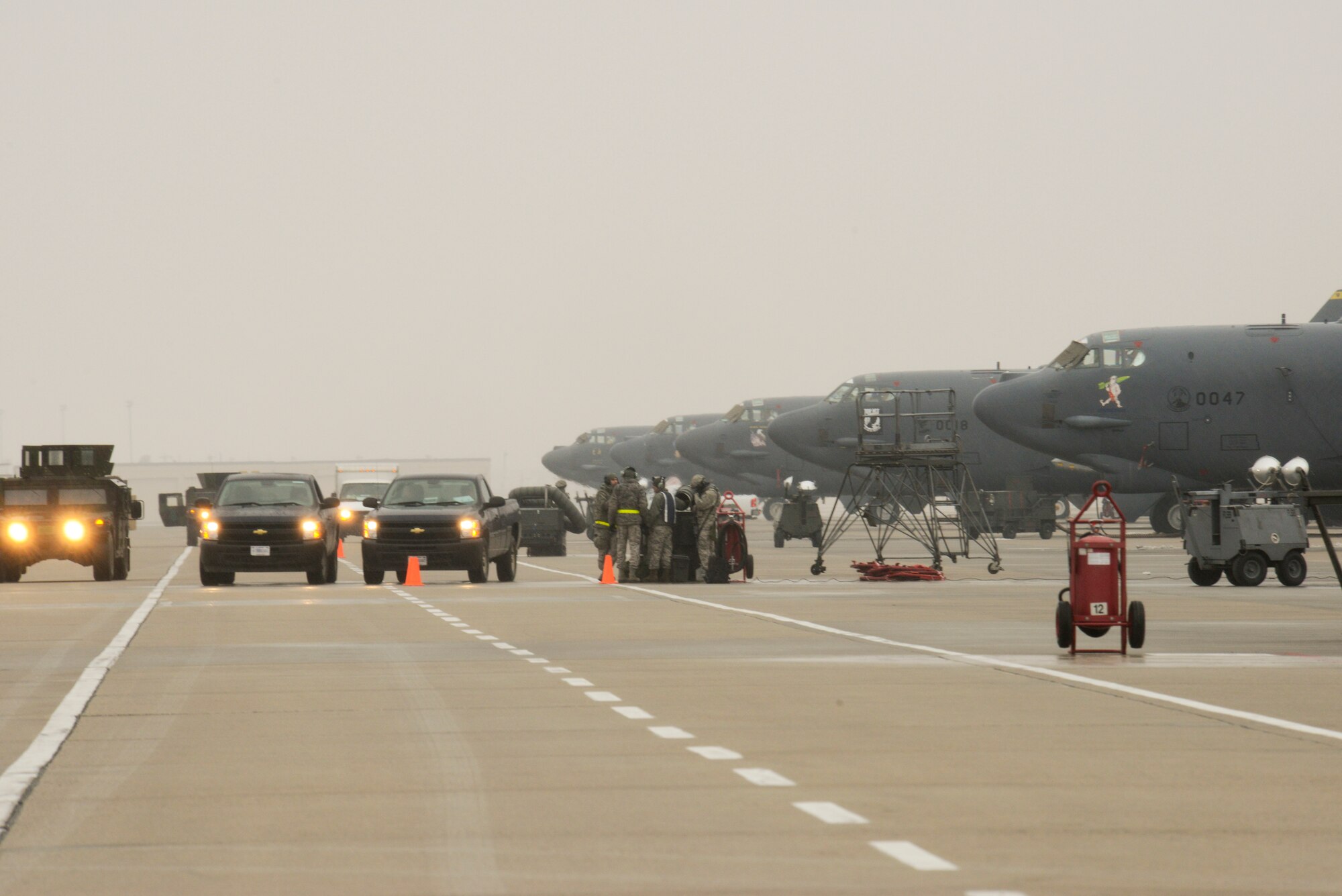 Airmen from the 5th Maintenance Group load weapons on a B-52H Stratofortress while Airmen from the 5th Security Forces Squadron provide security during an exercise on Minot Air Force Base, N.D., March 24, 2015. Air Force Global Strike Command routinely conducts training operations and exercises to ensure its forces can perform their mission when called upon at any time. (U.S. Air Force photo/Senior Airman Brittany Y. Bateman)