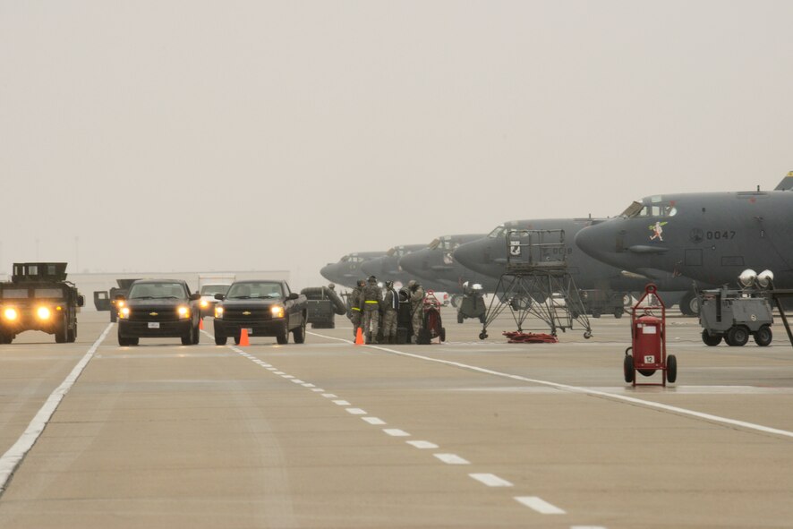 Airmen from the 5th Maintenance Group load weapons on a B-52H Stratofortress while Airmen from the 5th Security Forces Squadron provide security during an exercise on Minot Air Force Base, N.D., March 24, 2015. Air Force Global Strike Command routinely conducts training operations and exercises to ensure its forces can perform their mission when called upon at any time. (U.S. Air Force photo/Senior Airman Brittany Y. Bateman)