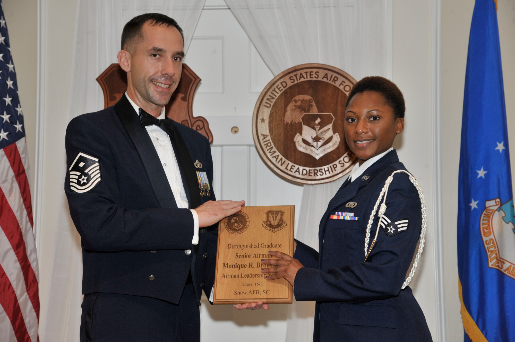 U.S. Air Force Senior Airman Monique Broussard, 31st Intelligence Squadron, receives a distinguished graduate award for the Senior Master Sgt. David B. Reid Airman Leadership School Class 15-3 from Master Sgt. Robert Finton, 20th Operations Support Squadron first sergeant, at Shaw Air Force Base, S.C., April 2, 2015. The distinguished graduate awards are given to the top 10 percent of the class for total point accumulation. (U.S. Air Force photo by Senior Airman Jonathan Bass/Released)