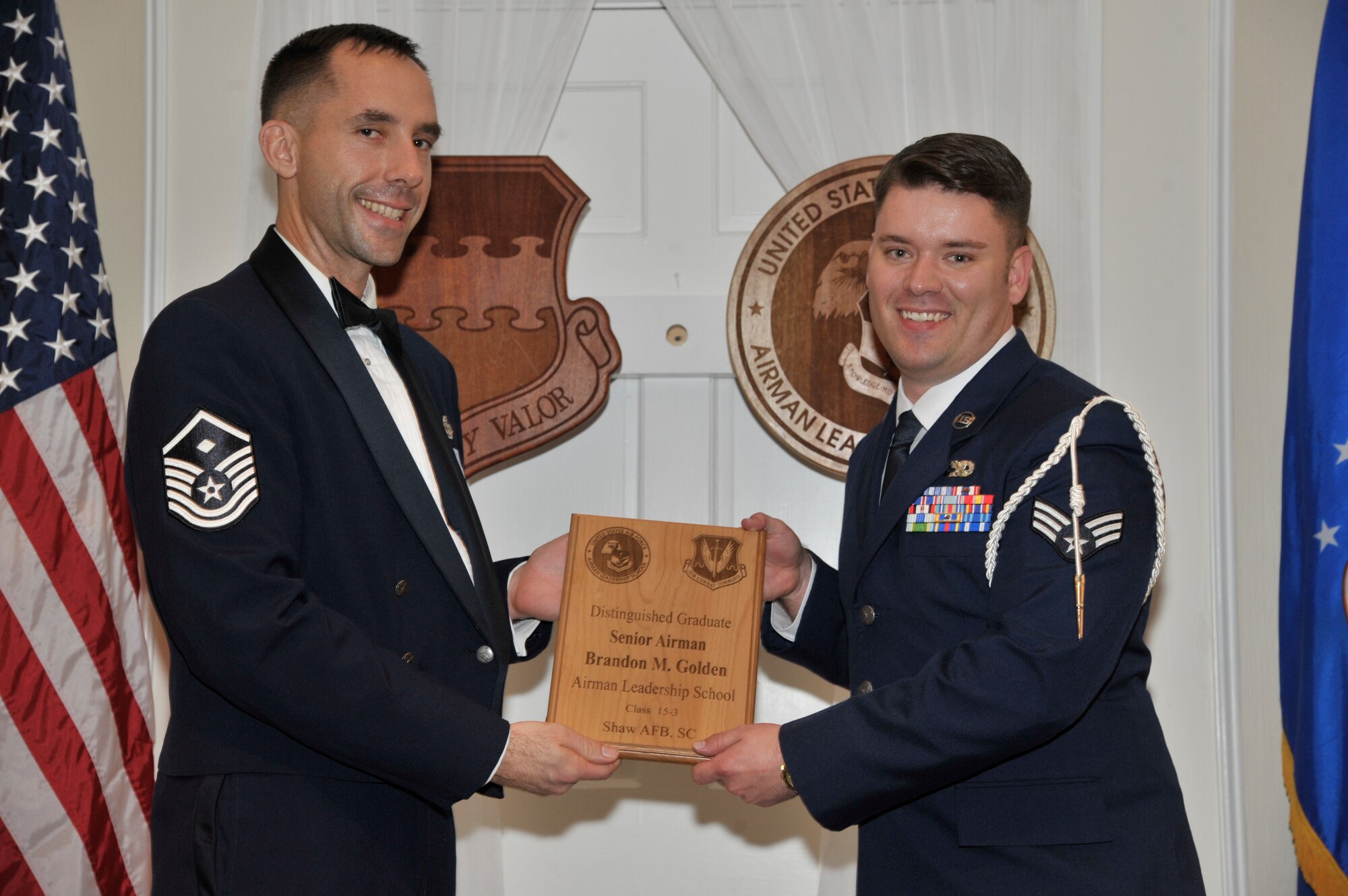 U.S. Air Force Senior Airman Brandon Golden, 20th Equipment Maintenance Squadron, receives a distinguished graduate award for the Senior Master Sgt. David B. Reid Airman Leadership School Class 15-3 from Master Sgt. Robert Finton, 20th Operations Support Squadron first sergeant, at Shaw Air Force Base, S.C., April 2, 2015. The distinguished graduate awards are given to the top 10 percent of the class for total point accumulation. (U.S. Air Force photo by Senior Airman Jonathan Bass/Released)
