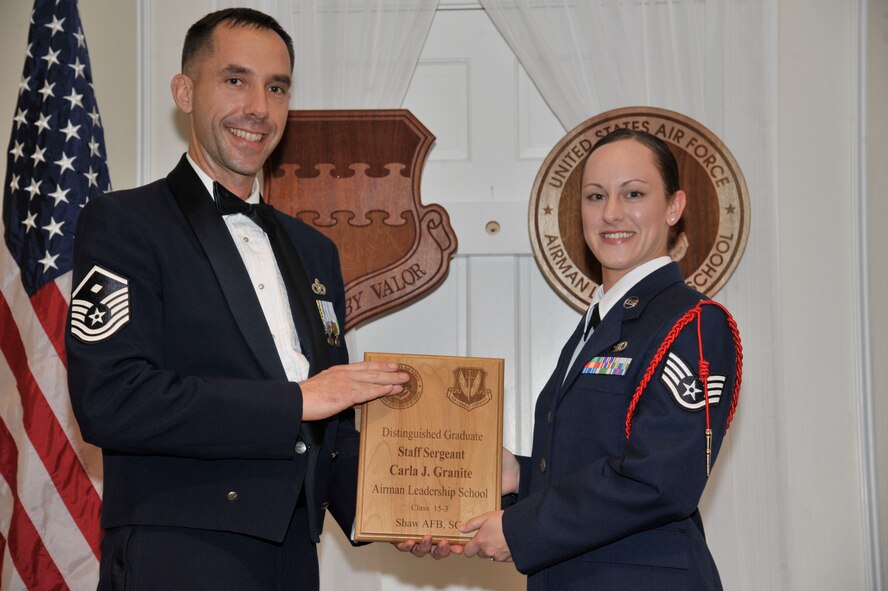 U.S. Air Force Staff Sgt. Carla Granite, 20th Aircraft Maintenance Squadron, receives a distinguished graduate award for the Senior Master Sgt. David B. Reid Airman Leadership School Class 15-3 from Master Sgt. Robert Finton, 20th Operations Support Squadron first sergeant, at Shaw Air Force Base, S.C., April 2, 2015. The distinguished graduate awards are given to the top 10 percent of the class for total point accumulation. (U.S. Air Force photo by Senior Airman Jonathan Bass/Released)