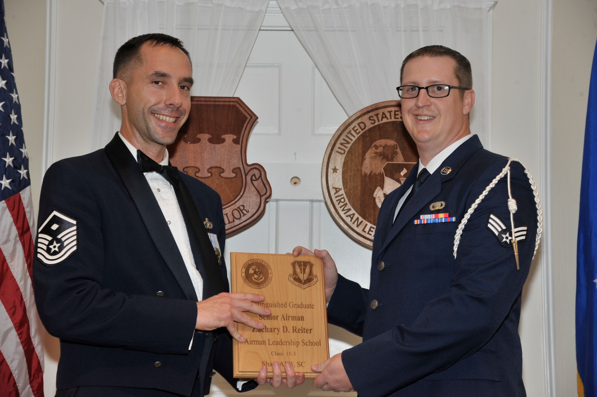 U.S. Air Force Senior Airman Zachary Reiter, 31st Intelligence Squadron, receives a distinguished graduate award for the Senior Master Sgt. David B. Reid Airman Leadership School Class 15-3 from Master Sgt. Robert Finton, 20th Operations Support Squadron first sergeant, at Shaw Air Force Base, S.C., April 2, 2015. The distinguished graduate awards are given to the top 10 percent of the class for total point accumulation. (U.S. Air Force photo by Senior Airman Jonathan Bass/Released)