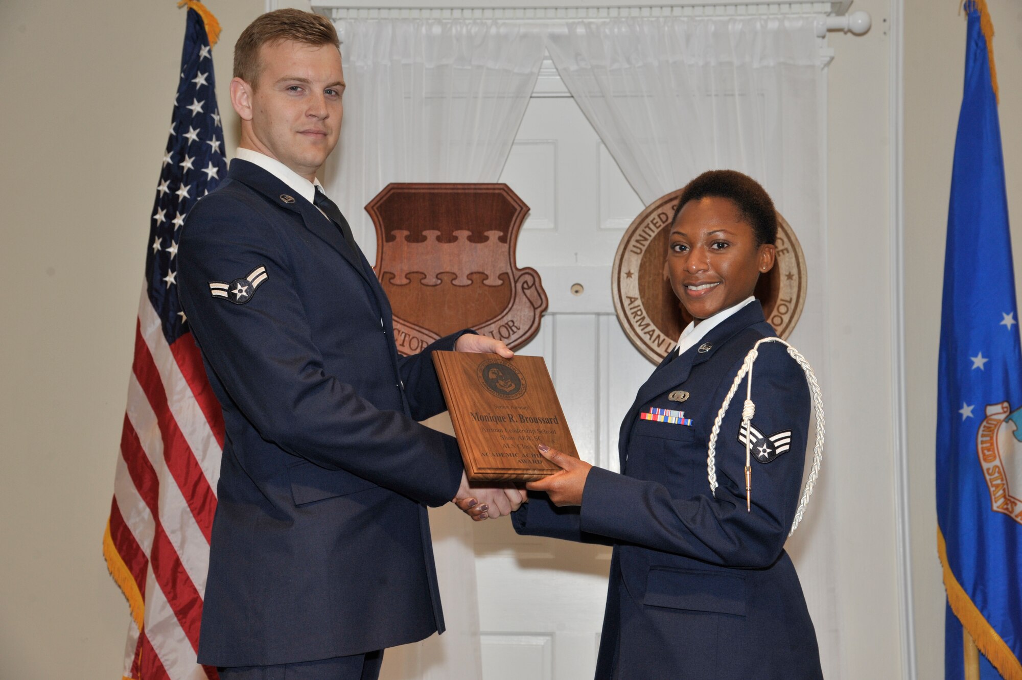 U.S. Air Force Senior Airman Monique Broussard, 31st Intelligence Squadron, receives the Senior Master Sgt. David B. Reid Airman Leadership School Academic Achievement award from Airman 1st Class David Maranto, 20th Component Maintenance Squadron test measurement and diagnostic equipment technician, during the ALS Class 15-3 graduation at Shaw Air Force Base, S.C., April 2, 2015. This award is given to the student with the highest point total. (U.S. Air Force photo by Senior Airman Jonathan Bass/Released)
