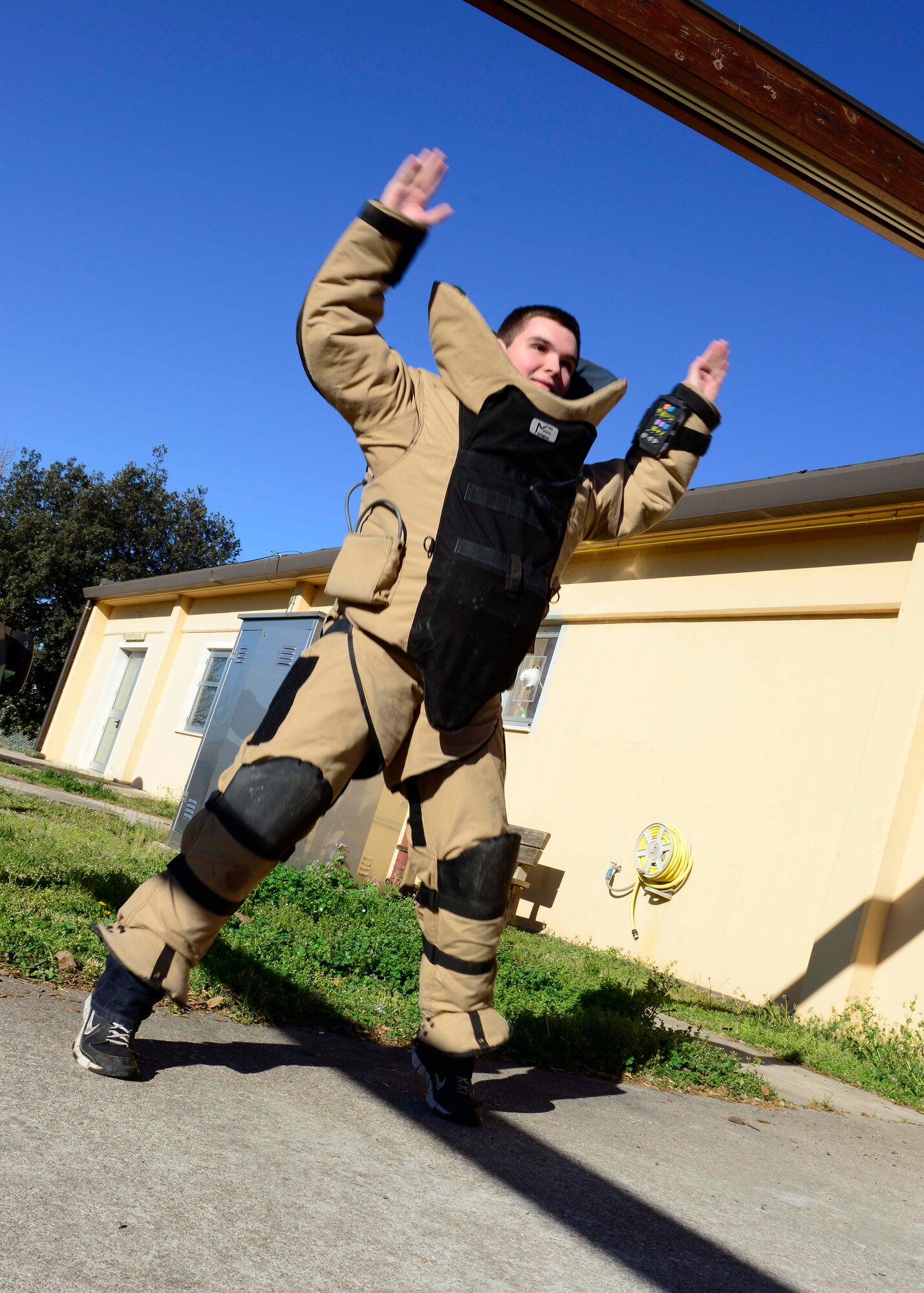 Jason Frost, Aviano student, executes an exercise while wearing a bomb suit, April 2, 2015, at Aviano Air Base, Italy. During his visit to the 31st Civil Engineer Squadron explosive ordnance flight, Frost was given the opportunity to operate equipment used by EOD Airmen. (U.S. Air Force photo by Senior Airman Areca T. Wilson/Released)