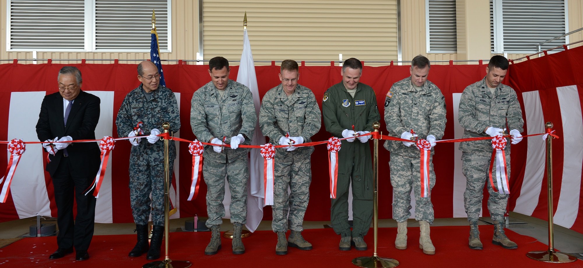 Center, Brig. Gen. David Krumm, 5th Air Force commander, and Col. Dale L. Landis II, 515th Air Mobility Operations Group commander, and other leaders cut the ribbon for the opening of the Mechanized Material Handling System March 23, 2015, at Yokota Air Base, Japan. The new MMHS will increase the capabilities of the 730th Air Mobility Squadron 167 percent. (U.S. Air Force photo by Senior Airman Desiree Economides/Released)
