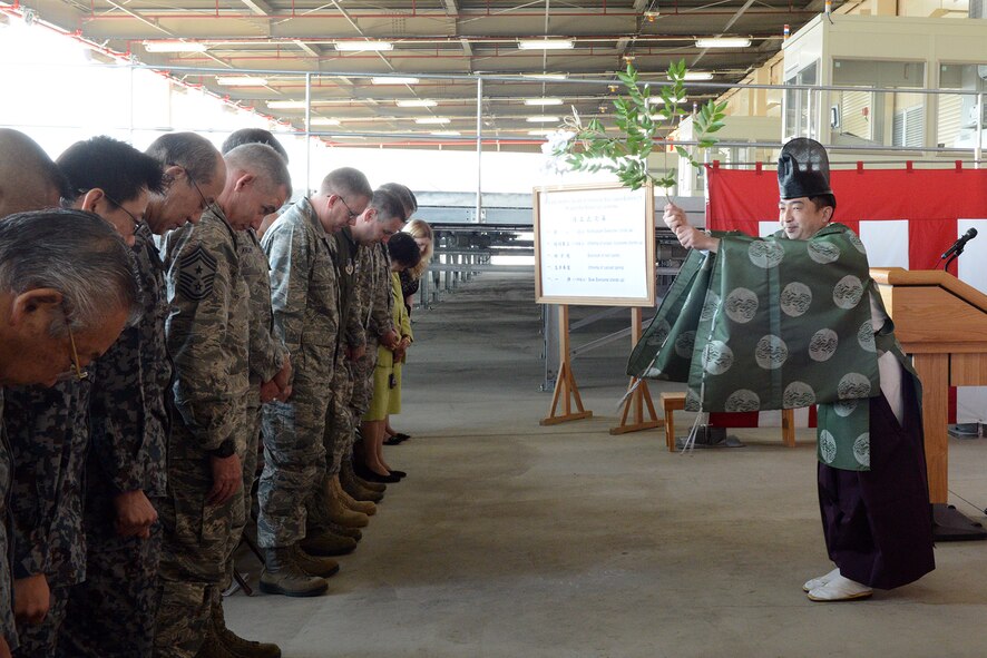 A Shinto Priest waves a purification wand over those assembled at the Mechanized Material Handling System ribbon cutting ceremony March 23, 2015, at Yokota Air Base, Japan. The priest performed a Shubatsu, or purification, ceremony as part of the ribbon cutting event for the MMHS.  (U.S. Air Force photo by Senior Airman Desiree Economides/Released)