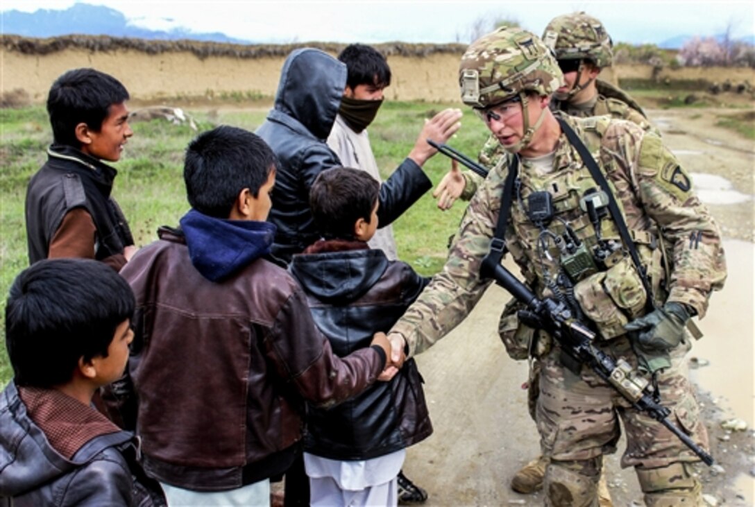 U.S. soldiers shake hands with Afghan children while patrolling through a village near Bagram Airfield, Afghanistan, March 24, 2015. The soldiers are assigned to the 101st Airborne Division's 3rd Battalion, 187th Infantry.