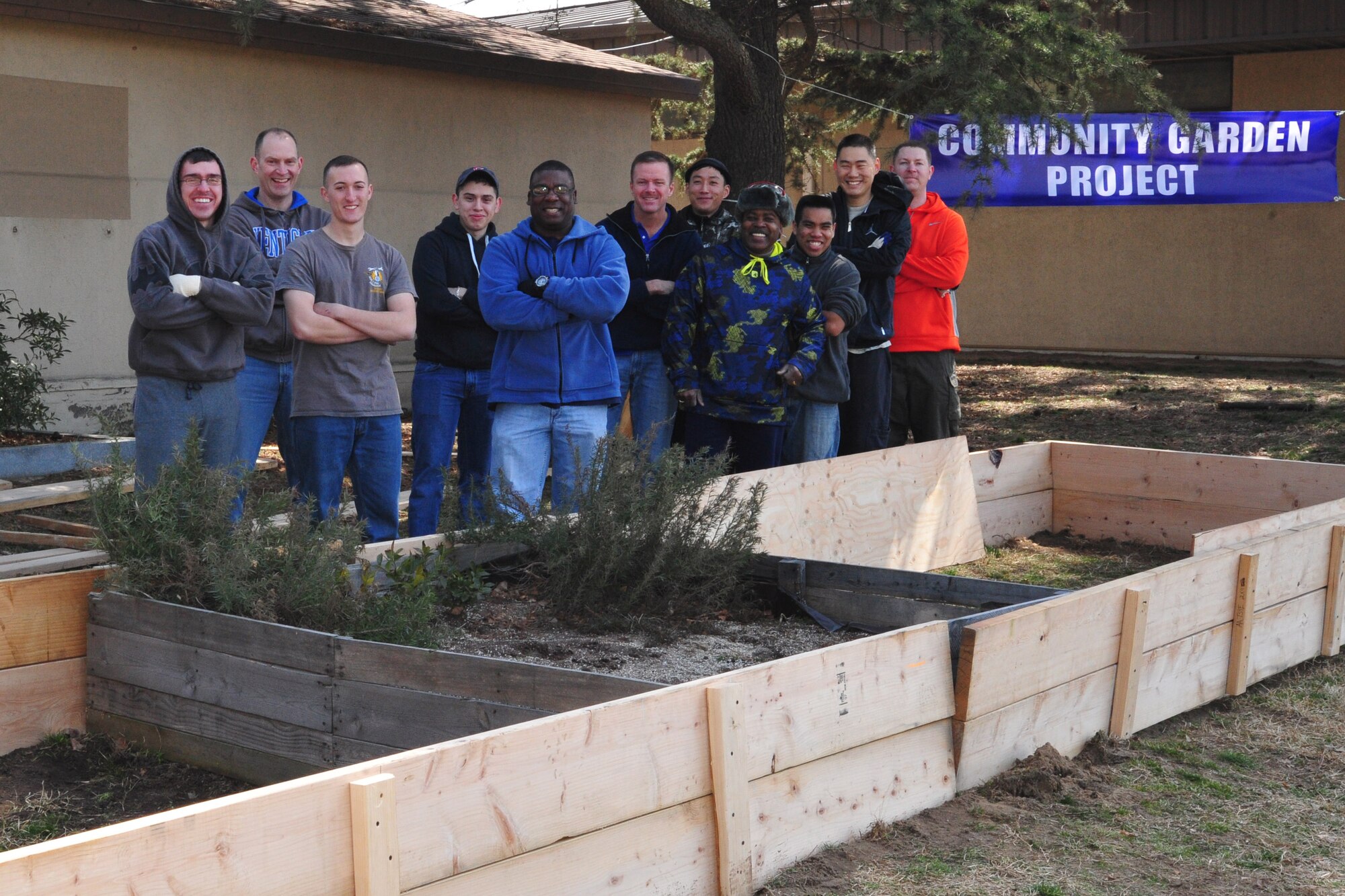 8th Fighter Wing Airmen pose for a group photo after building the initial portion of the foundation for “Wolf Pack Garden” in front of the Sonlight Inn, March 14, 2015, at Kunsan Air Base, Republic of Korea. The garden is part of a community initiative to promote healthy living for Wolf Pack Airmen. (U.S. Air Force photo by Capt. Reba Good/Released)