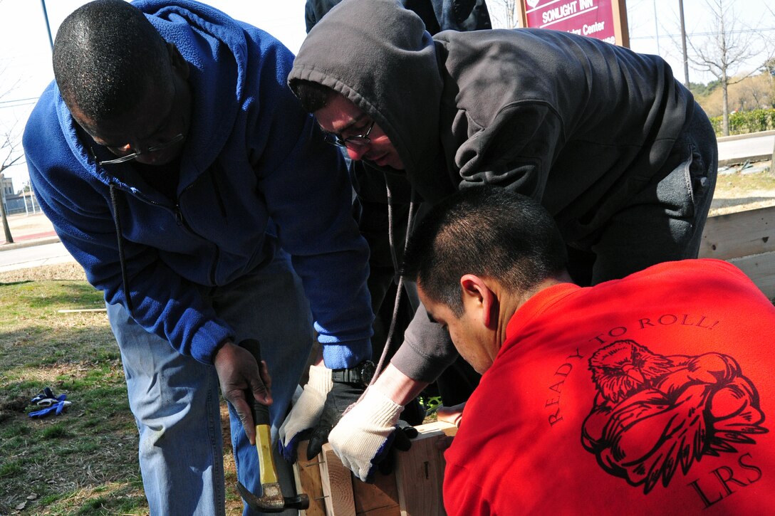 Chief Master Sgt. Lee “Wolf Chief” Barr, 8th Fighter Wing command chief, hammers nails to secure the retaining walls together for “Wolf Pack Garden” in front of the Sonlight Inn, March 14, 2015, at Kunsan Air Base, Republic of Korea. The garden is part of a community initiative to promote healthy living for Wolf Pack Airmen. (U.S. Air Force photo by Tech. Sgt. George Maddon/Released)