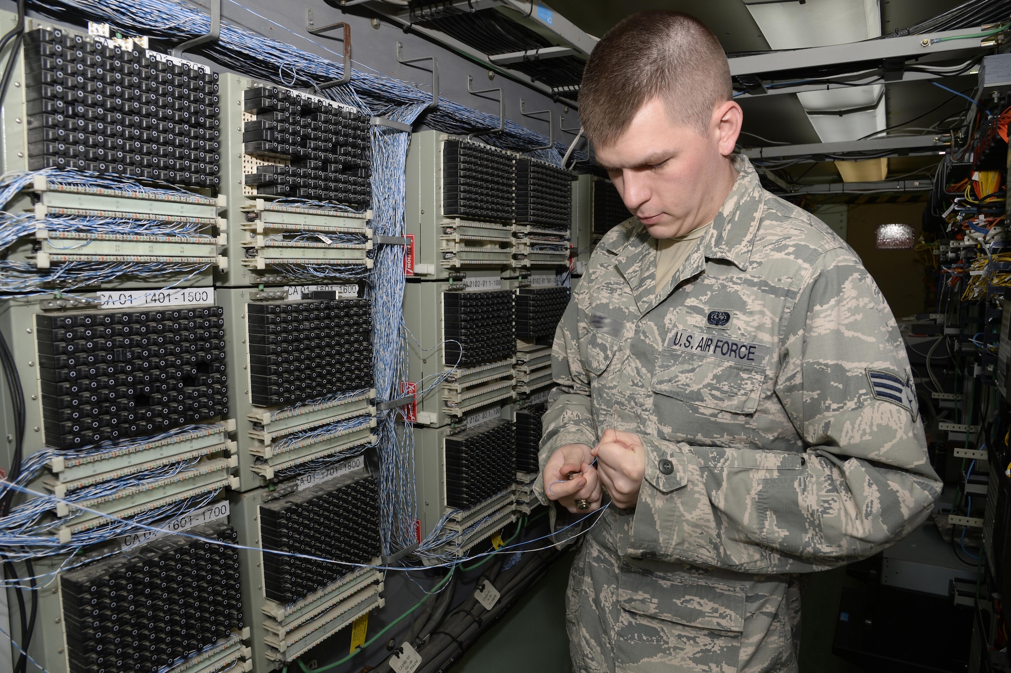 Senior Airman Christopher, client service technician, prepares wiring for a new telephone line at an undisclosed location in Southwest Asia March 30, 2015. Airmen of the Expeditionary Communication Squadron client service technician shop are instrumental in keeping communication channels open to ensure mission accomplishment. Christopher is currently deployed from Mountain Home Air Force Base, Idaho. (U.S. Air Force photo/Tech. Sgt. Marie Brown/RELEASED)