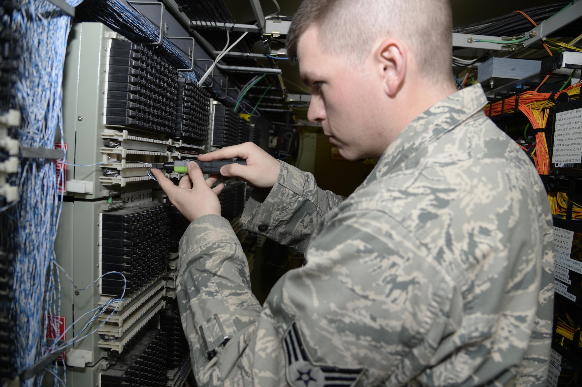 Senior Airman Christopher, client service technician, connects wiring for a new telephone line at an undisclosed location in Southwest Asia March 30, 2015. Client service technicians in the telephone section maintain over 2,000 telephones on base. Christopher is currently deployed from Mountain Home Air Force Base, Idaho. (U.S. Air Force photo/Tech. Sgt. Marie Brown/RELEASED)