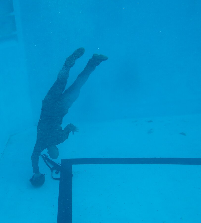 Cpl. Taylor K. Eversole, a U.S. Marine with the 26th Marine Expeditionary Unit, recovers a rifle and helmet after conducting a deep water gear shed during a swim qualification course at the Area 5 pool aboard Marine Corps Base Camp Lejeune, N.C., March 17, 2015. The deep water gear shed tests Marines abilities to remove protective posture equipment while submerged in water. (U.S. Marine Corps photo by Cpl. Joshua W. Brown/Released)