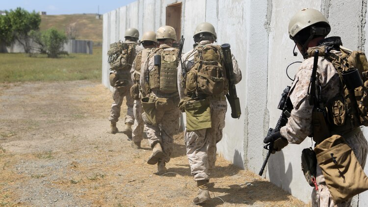 Marines with Charlie Company, 1st Reconnaissance Battalion, run into a compound after breaching a door during a live-fire raid at Range 226 aboard Camp Pendleton, Calif., April 1, 2015. The company conducted the live-fire exercise as part of a predeployment workup in support of the 13th Marine Expeditionary Unit.