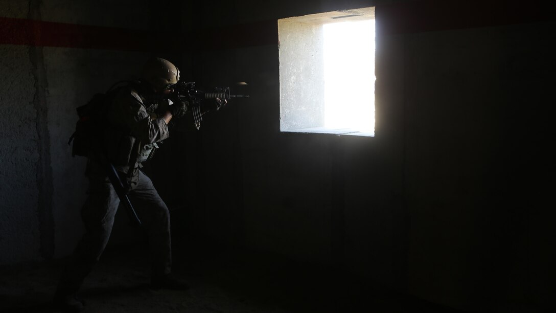 Sergeant Tahachee Appodaca, recon communicator, Charlie Company, 1st Reconnaissance Battalion, engages targets from inside a compound during a live-fire raid at Range 226 aboard Camp Pendleton, Calif., April 1, 2015. Appodaca, a native of Bakersfield, Calif., and the company conducted the live-fire exercise as part of a predeployment workup in support of the 13th Marine Expeditionary Unit. 