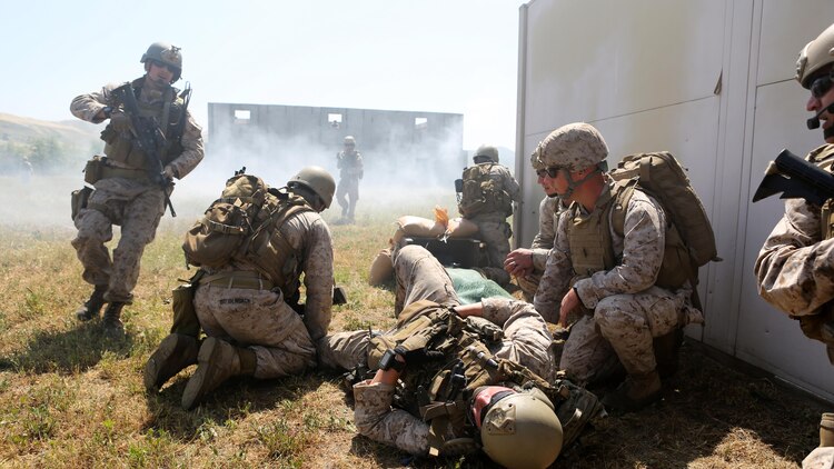 Marines with Charlie Company, 1st Reconnaissance Battalion, provide medical aid to a simulated casualty during a live-fire raid at Range 226 aboard Camp Pendleton, Calif., April 1, 2015. The company conducted the live-fire exercise as part of a predeployment workup in support of the 13th Marine Expeditionary Unit.