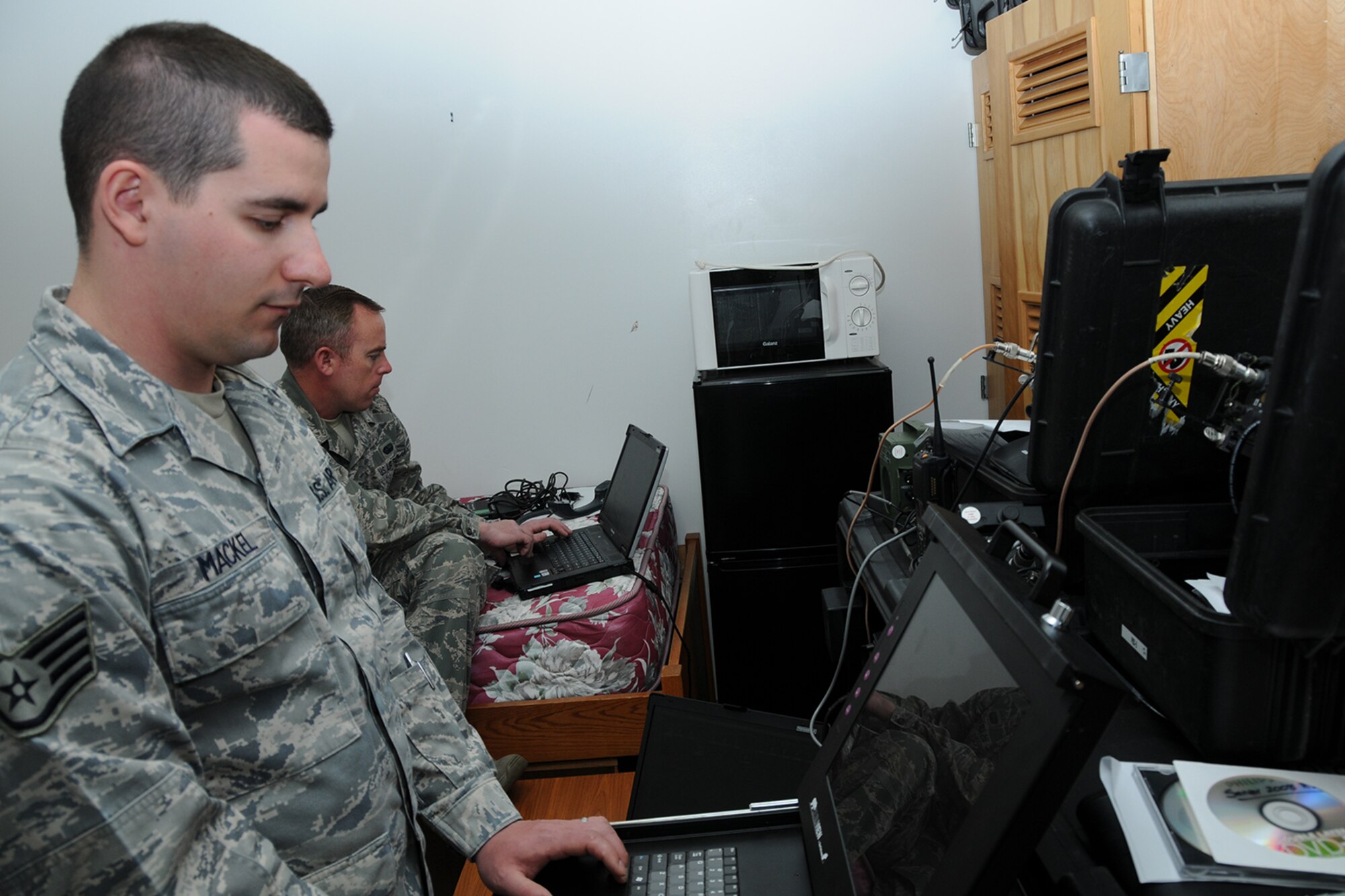 Air Force Reserve Staff Sgt. Greg Mackel, a Cyber Systems Technician assigned to the 910th Communications Squadron (CS), rebuilds a server for the Joint Incident Site Communications Capability (JISCC) system while Tech. Sgt. Gill Martin, also a 910th CS Cyber Systems Technician, adds a laptop to the 910th’s communications domain here, March 17, 2015.The work of Mackel and Martin allowed the consolidation of radios, where one radio can receive several UHF and VHF channels, eliminating the need to carry multiple radios as part of the squadron’s support capability of the 910th Airlift Wing’s two week aerial spray mission over the nearby Utah Test and Training Range, March 9 – 20, 2015. 
