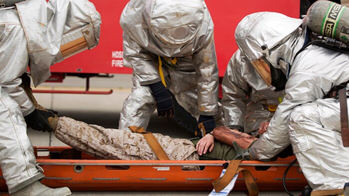 Aircraft Rescue Firefighters with Headquarters and Headquarters Squadron work together to evacuate a casualty during the mass casualty exercise aboard Marine Corps Air Station Iwakuni, Japan, April 3, 2015. MCAS Iwakuni conducted the exercise in preparation for the Japan Maritime Self-Defense Force/MCAS Iwakuni Friendship Day 2015 Air Show. The exercise simulated an aircraft crash and oil spill in a crowded area.