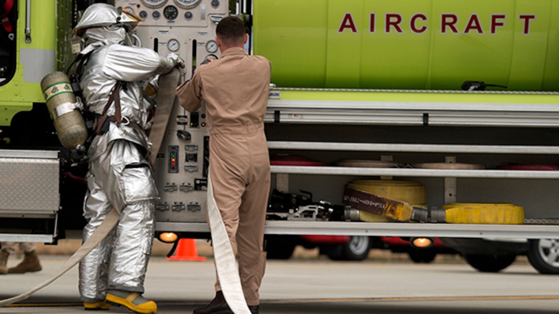 Aircraft Rescue Firefighters with Headquarters and Headquarters Squadron prepare to put out a simulated fire at the aircraft crash site during the mass casualty exercise aboard Marine Corps Air Station Iwakuni, Japan, April 3, 2015. MCAS Iwakuni conducted the exercise in preparation for Japan Maritime Self-Defense Force/MCAS Iwakuni Friendship Day 2015 Air Show. The exercise simulated an aircraft crash and oil spill in a crowded area.