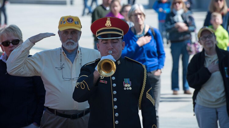 Staff Sgt. Kevin Gebo, a U.S. Army Band Pershing’s Own bugler, plays Taps for the veterans and the crowd, who gathered during a wreath laying ceremony in honor of the veterans of the Battle of Okinawa  at the World War II Memorial in Washington April 1, 2015. On April 1, 1945, allied forces invaded the island of Okinawa. The battle lasted 82 days amassing high totals of allied, Japanese and civilian casualties.