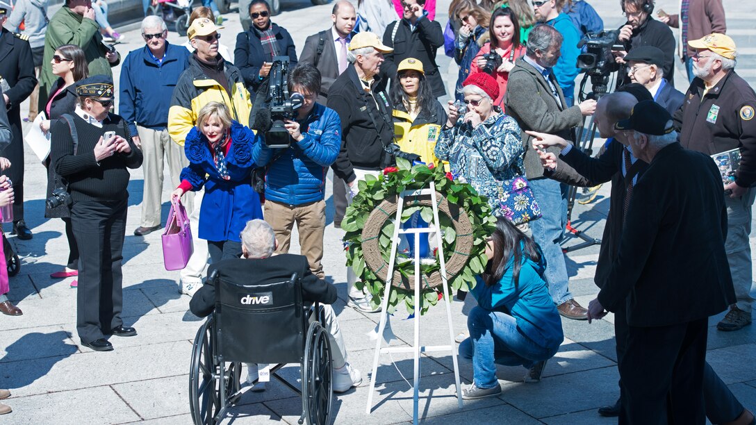 A crowd gathers around John ‘Jack’ Cassidy, a World War II and Navy veteran, during a wreath laying ceremony in honor of the 70th anniversary of the Battle of Okinawa at the World War II Memorial in Washington April 1, 2015. On April 1, 1945, allied forces invaded the island of Okinawa. The battle lasted 82 days amassing high totals of allied, Japanese and civilian casualties.