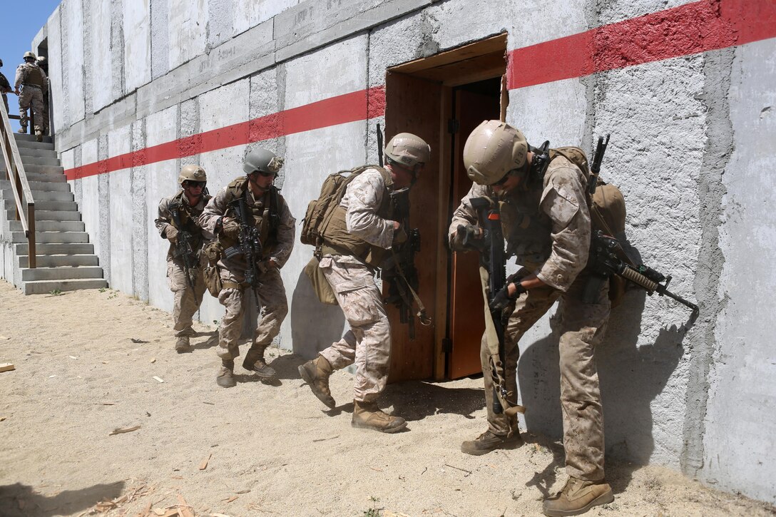 Marines with Charlie Company, 1st Reconnaissance Battalion, rush into a compound after breaching a door during a live-fire raid at Range 226 aboard Camp Pendleton, Calif., April 1, 2015. The company conducted the live-fire exercise as part of a predeployment workup in support of the 13th Marine Expeditionary Unit. (U.S. Marine Corps photo by Sgt. Joseph Scanlan / released)