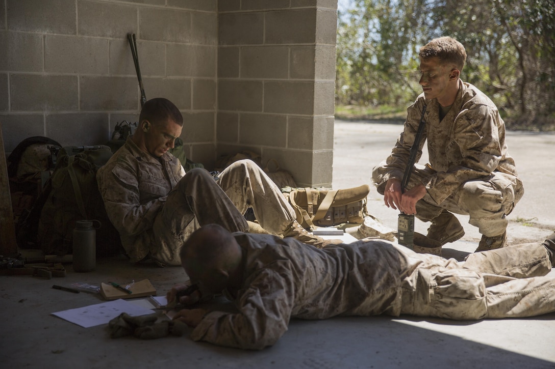 Marines with 1st Battalion, 8th Marine Regiment check radio communications and study possible routes during the scout sniper assessment and selection process aboard Camp Lejeune, N.C., March 31, 2015. The assessment process lasted for two weeks. Candidates were tested on their physical fitness and mental discipline; necessary skills for a scout sniper. (U.S. Marine Corps photo by Lance Cpl. Olivia McDonald/Released)