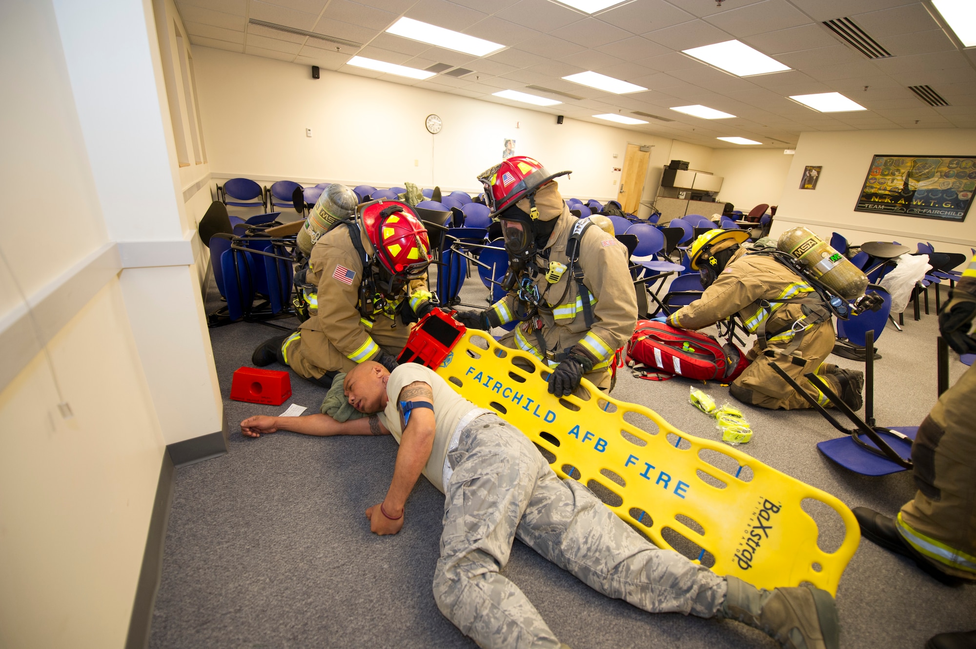 Firefighters from the 92nd Civil Engineer Squadron respond to a simulated explosion during a emergency management exercise March 30, 2015, at Fairchild Air Force Base, Wash. The firefighters practiced placing victims onto stretchers for transport during the exercise. (U.S. Air Force photo/Airman 1st Class Nicolo J. Daniello)