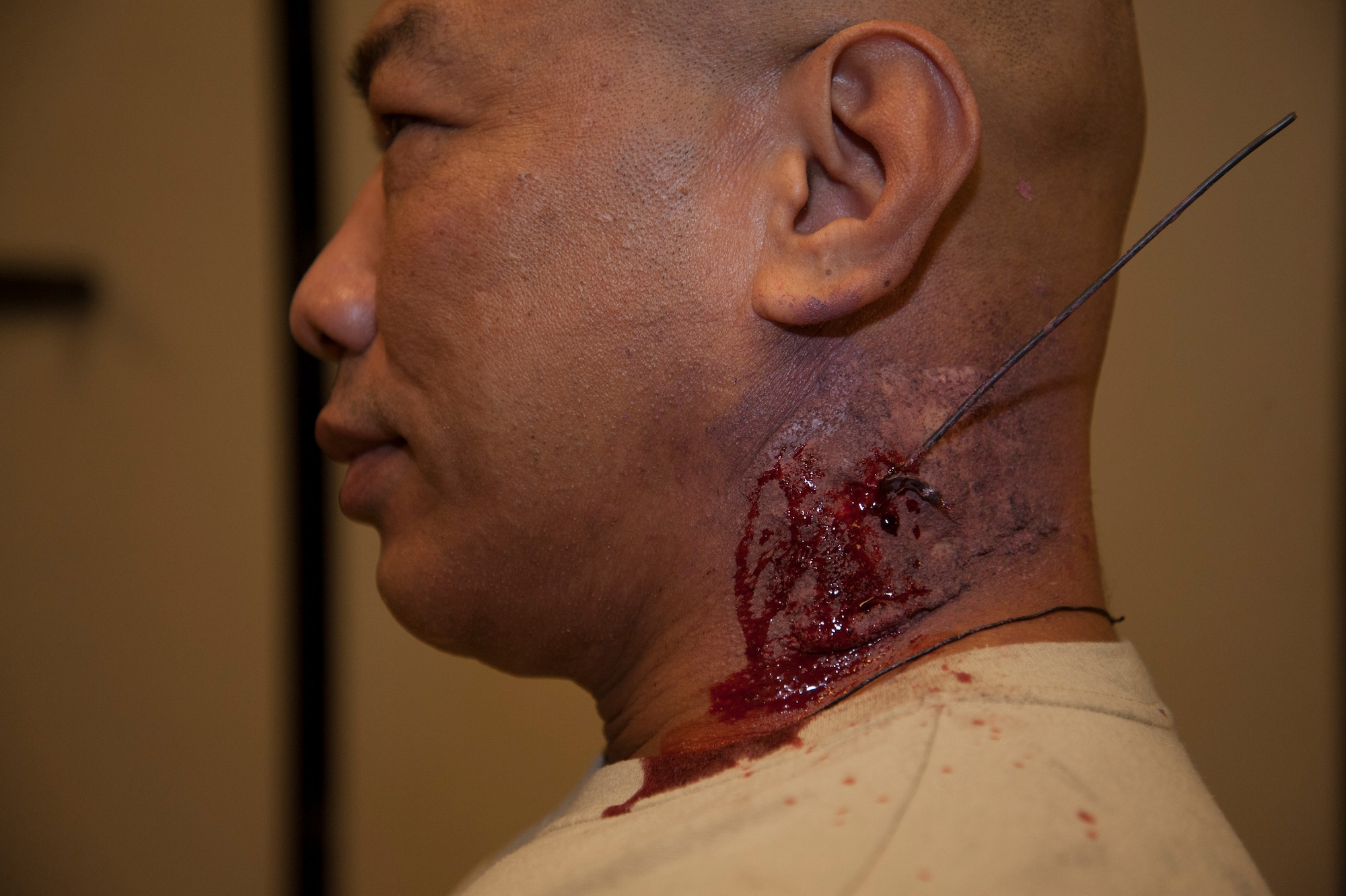 Master Sgt. Ray Ordonio, 92nd Maintenance Squadron assistant accessory flight assistant flight chief, sits after medical moulage was applied to his neck as part of a emergency management exercise March 30, 2015, at Fairchild Air Force Base, Wash. Role players had make-up applied to various parts of their bodies to keep it realistic for the exercise. (U.S. Air Force photo/Airman 1st Class Nicolo J. Daniello)