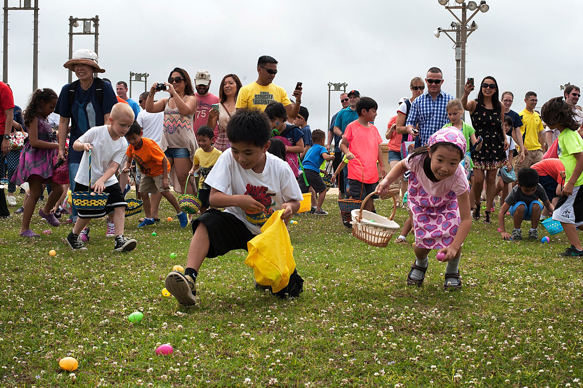 Children race to gather eggs during the 18th Force Support Squadron EGGsplosion at the Four Diamonds Softball Complex, Kadena Air Base, Japan, April 4, 2015. EGGsplosion is an annual event and includes multiple Easter egg hunts, cultural demonstrations, food and prizes. (U.S. Air Force photo by Staff Sgt. Rachelle Coleman)