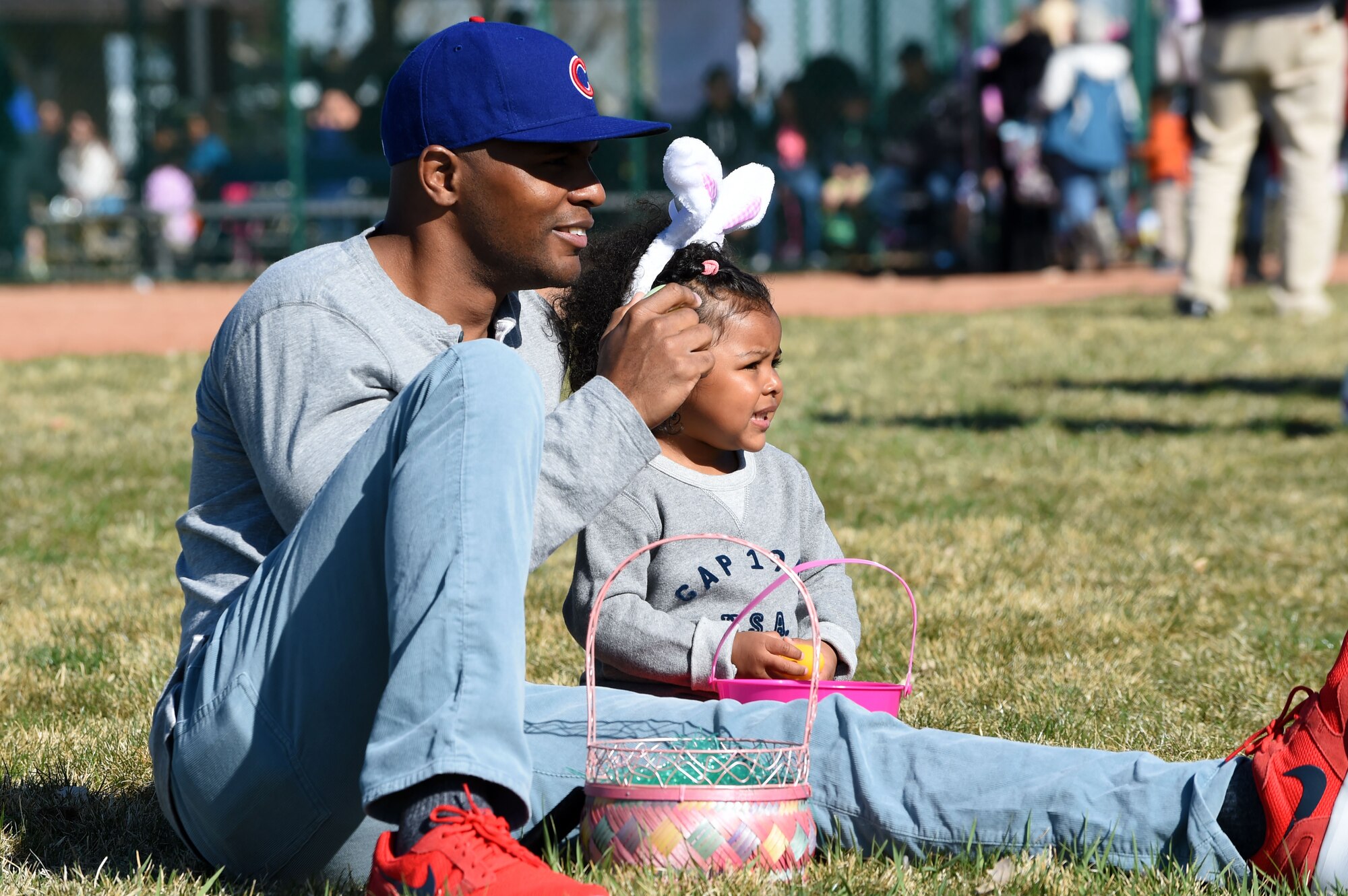 Team Buckley members sit down and relax after the Easter egg hunt during the Breakfast with Bunny event April 4, 2015, at the softball fields on Buckley Air Force Base, Colo. The event included a free pancake breakfast and Easter egg hunts for different age groups. (U.S. Air Force photo by Airman 1st Class Emily E. Amyotte/Released)