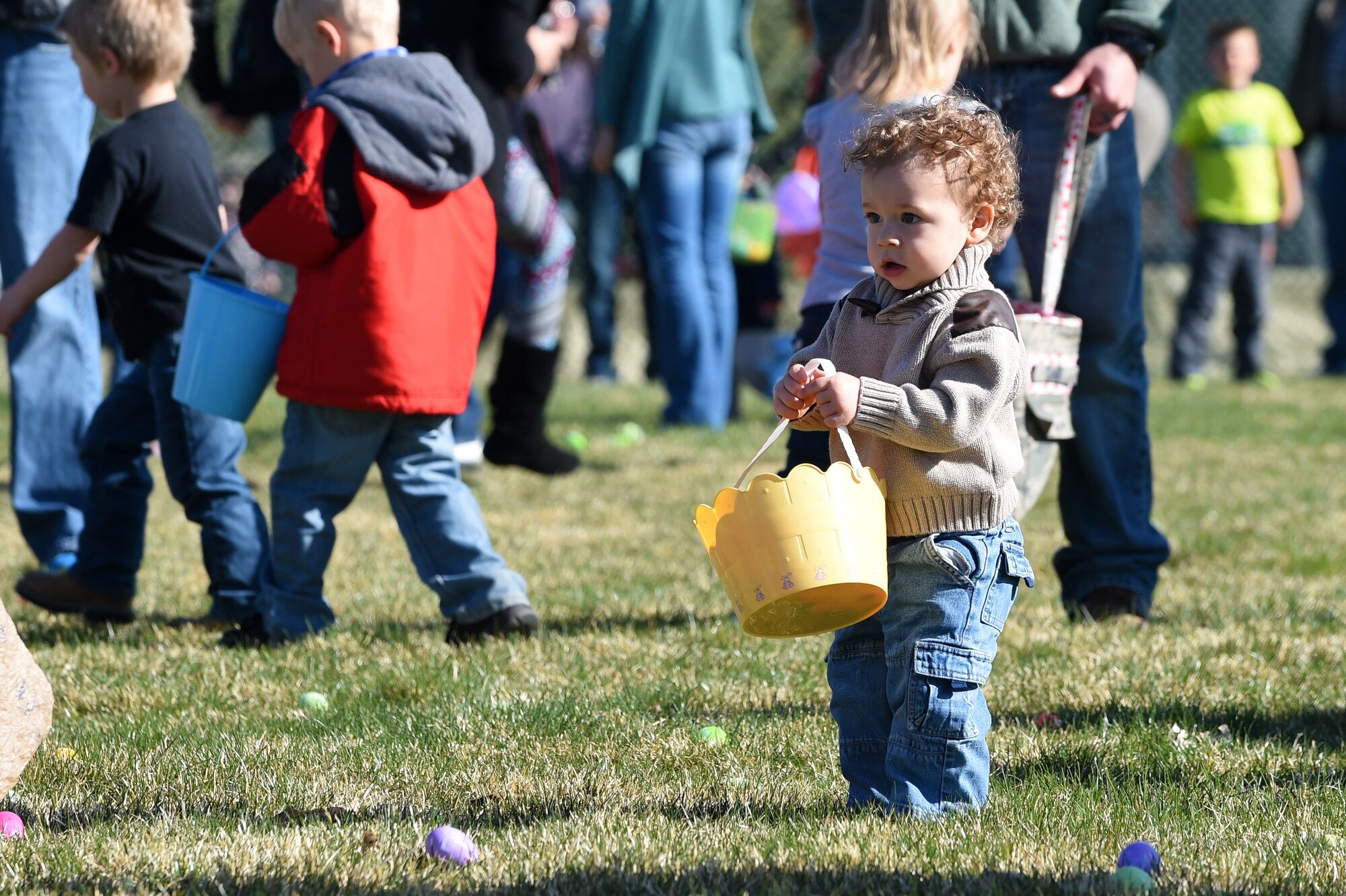 A Team Buckley child searches for Easter eggs during the Breakfast with Bunny event April 4, 2015, at the softball fields on Buckley Air Force Base, Colo. The event included a free pancake breakfast and Easter egg hunts for different age groups. (U.S. Air Force photo by Airman 1st Class Emily E. Amyotte/Released)