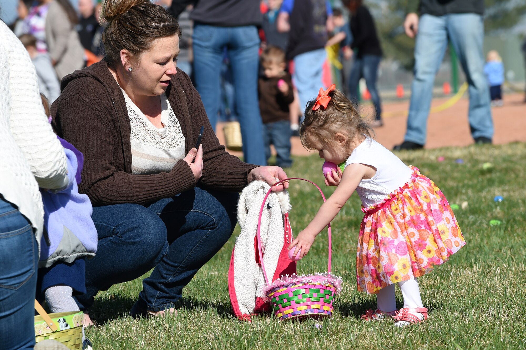 Team Buckley members search through their Easter eggs during the Breakfast with Bunny event April 4, 2015, at the softball fields on Buckley Air Force Base, Colo. The event included a free pancake breakfast and Easter egg hunts for different age groups. (U.S. Air Force photo by Airman 1st Class Emily E. Amyotte/Released)