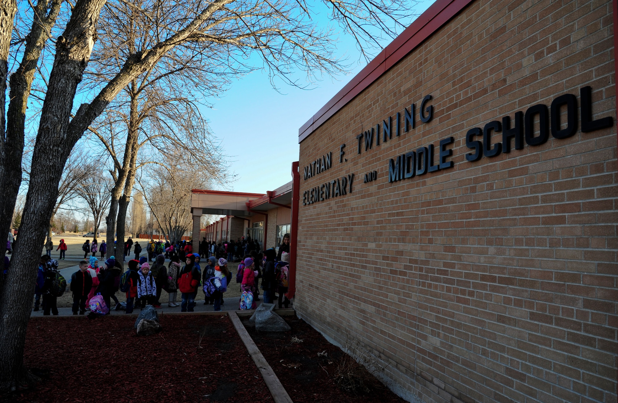 Students wait for the first bell to ring outside Nathan Twining Elementary and Middle School April 6, 2015, on Grand Forks Air Force Base, N.D. Twining hosts grades K-8 for children of military families. (U.S. Air Force photo by Airman 1st Class Ryan Sparks/released)