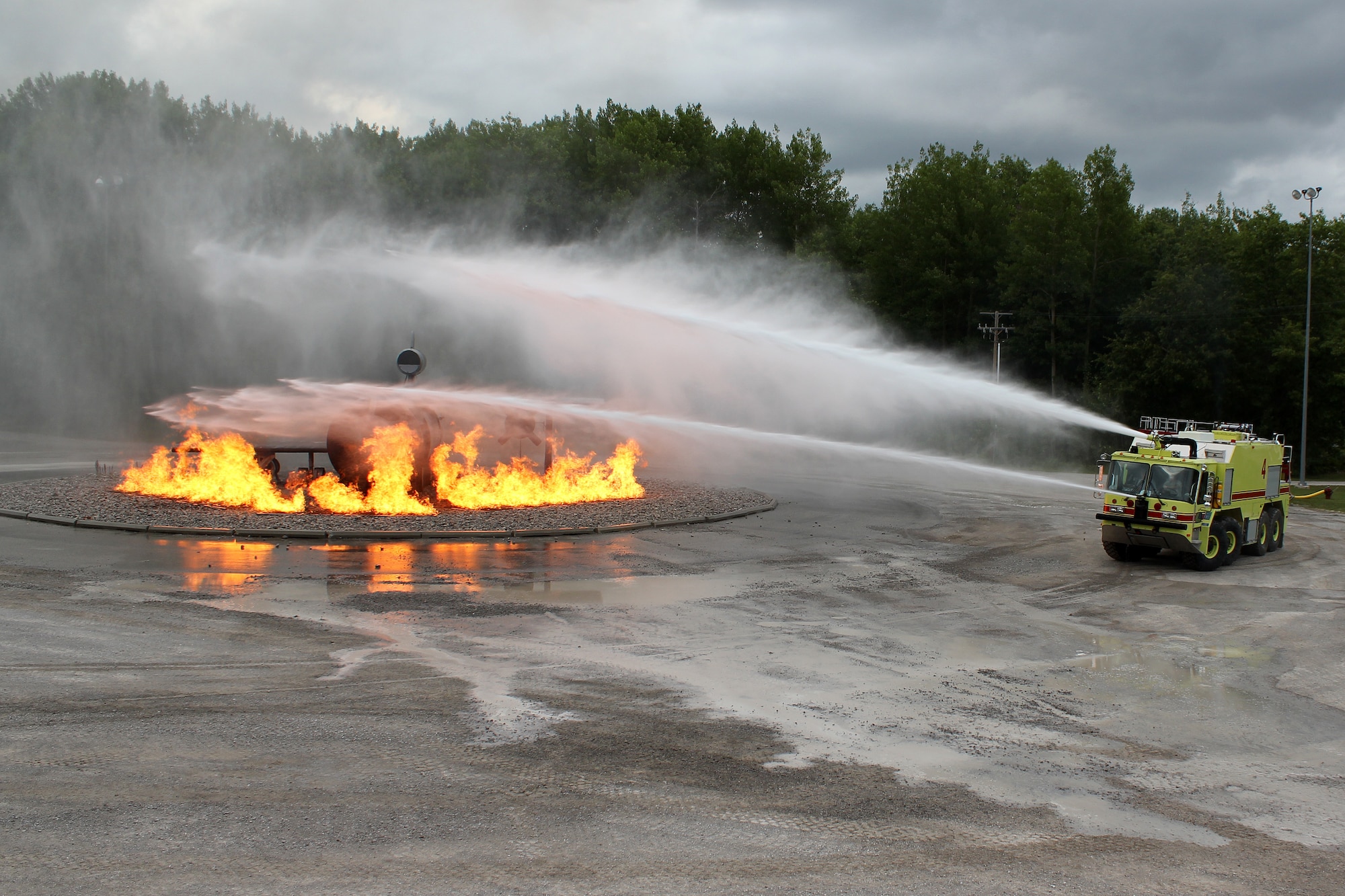 Firefighters from the 179th Airlift Wing, Ohio Air National Guard, spray water on a simulated aircraft fire during a training deployment to the Alpena Combat Readiness Training Center, Mich., Aug. 19, 2014. The firefighters spent a week at Alpena, training on live-fire exercises involving a simulated structure fire and aircraft fire, and on various rescue scenarios. (U.S. Air National Guard photo by Tech. Sgt. Dan Heaton)