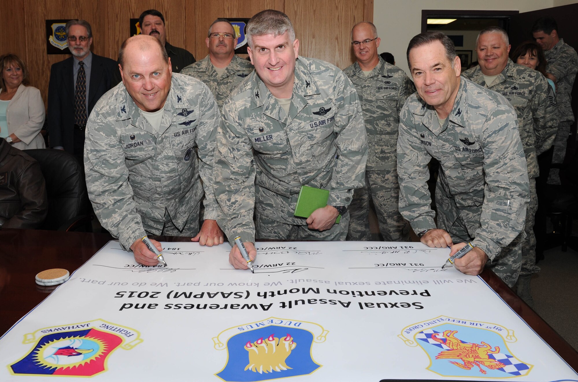 (Left to right) Commanders Col. Jeffry Jordan, 184th Intelligence Wing, Col. Samuel Miller, 22nd Air Refueling Wing, and Col. Mark S. Larson, 931st Air Refueling Group, sign a pledge officially endorsing Sexual Assault Awareness and Prevention Month at McConnell Air Force Base, Kan., April 6, 2015.  April 2015 marks the 14th observance of SAAPM.  (U.S. Air Force photo by Airman 1st Class Tara Fadenrecht)