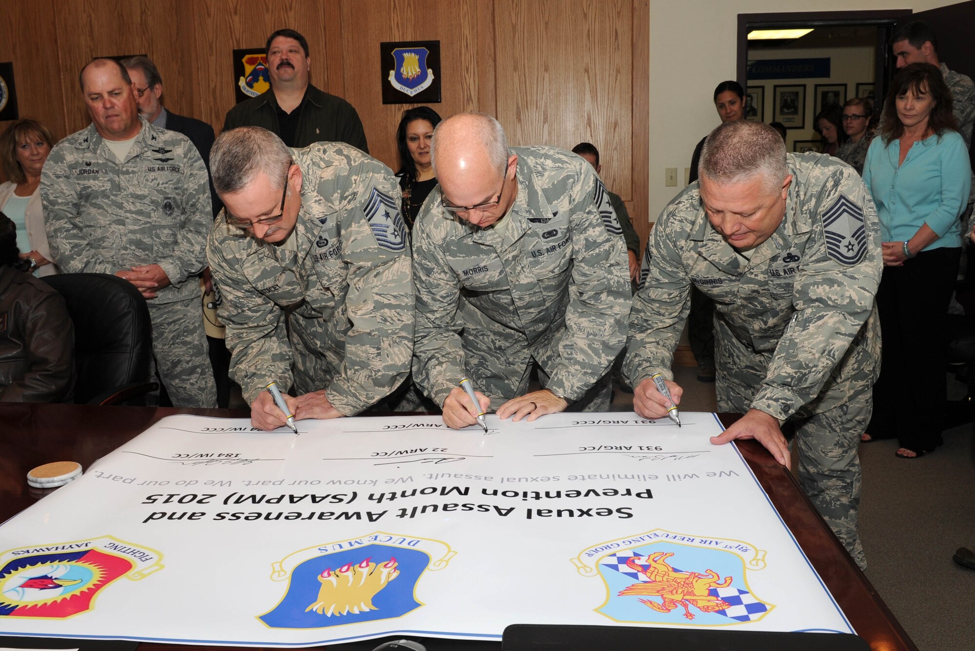 (Left to right) Command chiefs Chief Master Sgt. William Stacey, 184th Intelligence Wing, Chief Master Sgt. Michael Morris, 22nd Air Refueling Wing, and Chief Master Sgt. Paul McGinnis, 931st Maintenance superintendent, sign a pledge officially endorsing Sexual Assault Awareness and Prevention Month at McConnell Air Force Base, Kan., April 6, 2015.  April 2015 marks the 14th observance of SAAPM. It is recognized nationally and internationally by military and civilian communities. In the late 1980s, the National Coalition Against Sexual Assault (NCASA) led an initiative to select a designated time period to promote awareness.  (U.S. Air Force photo by Airman 1st Class Tara Fadenrecht)