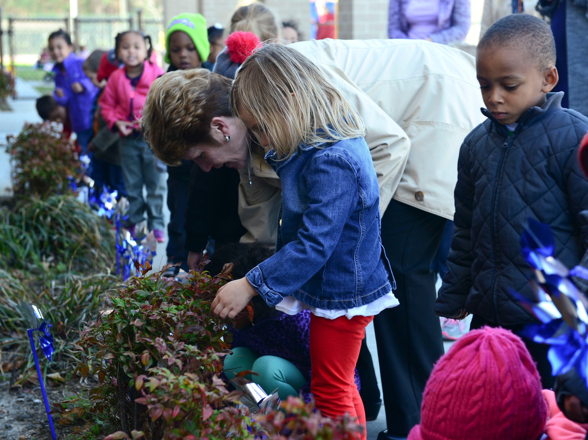 Children and caretakers from the Pershing Child Development Center take part in pinwheel planting as part of Child Abuse Prevention Month at Fort Eustis, Va., April 2, 2015.  The Joint Base Langley-Eustis Family Advocacy Program will host events throughout the month, to show support for military children and to provide parents with lessons and tips.  (U.S. Air Force photo by Senior Airman Kimberly Nagle/Released) 