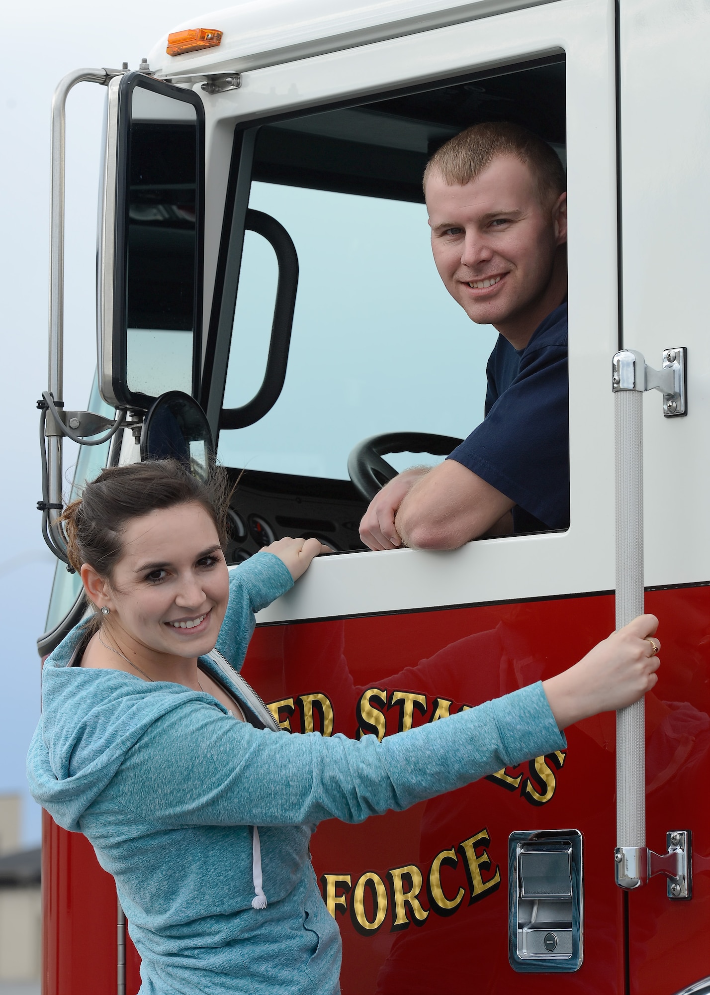 Mallory and Tech. Sgt. Chad Diehl, 436th Civil Engineer Squadron firefighter, pose with a fire engine at the main fire station March 31, 2015, on Dover Air Force Base, Del. Mallory kept busy through running monthly road-races during Chad's last deployment to the Middle East. (U.S. Air Force photo/Greg L. Davis)