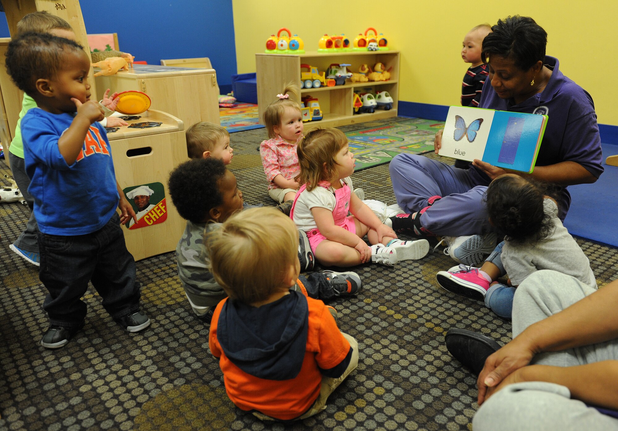 Karen Parker, 81st Force Support Squadron Child Development Center caregiver, reads to children March 3, 2015, at the Keesler Child Development Center, Keesler Air Force Base, Miss. The CDC uses hands-on learning techniques to help children ranging from 6 weeks to 5 years old learn reading, speaking and comprehension skills. (U.S. Air Force photo by Senior Airman Holly Mansfield)