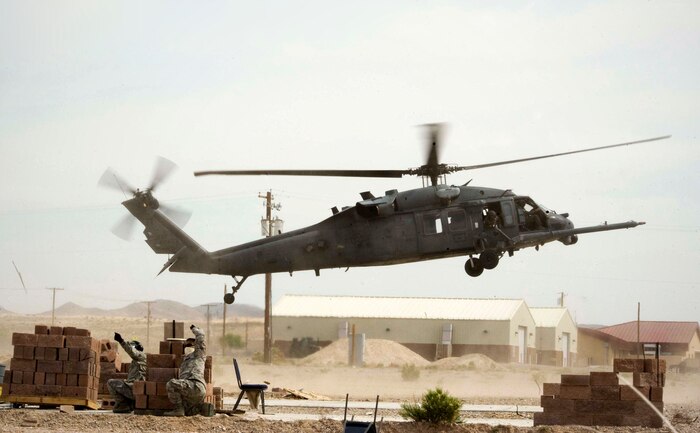Participants in Operation Joint Medic exercise motion their team members for medical support as an HH-60G Pave Hawk assigned to the 66th Rescue Squadron prepares to land at Camp Cobra on Nellis Air Force Base, Nev., March 31, 2015. The exercise challenged medical personnel with receiving patients in critical care through air support. (U.S. Air Force photo by Airman 1st Class Rachel Loftis) 