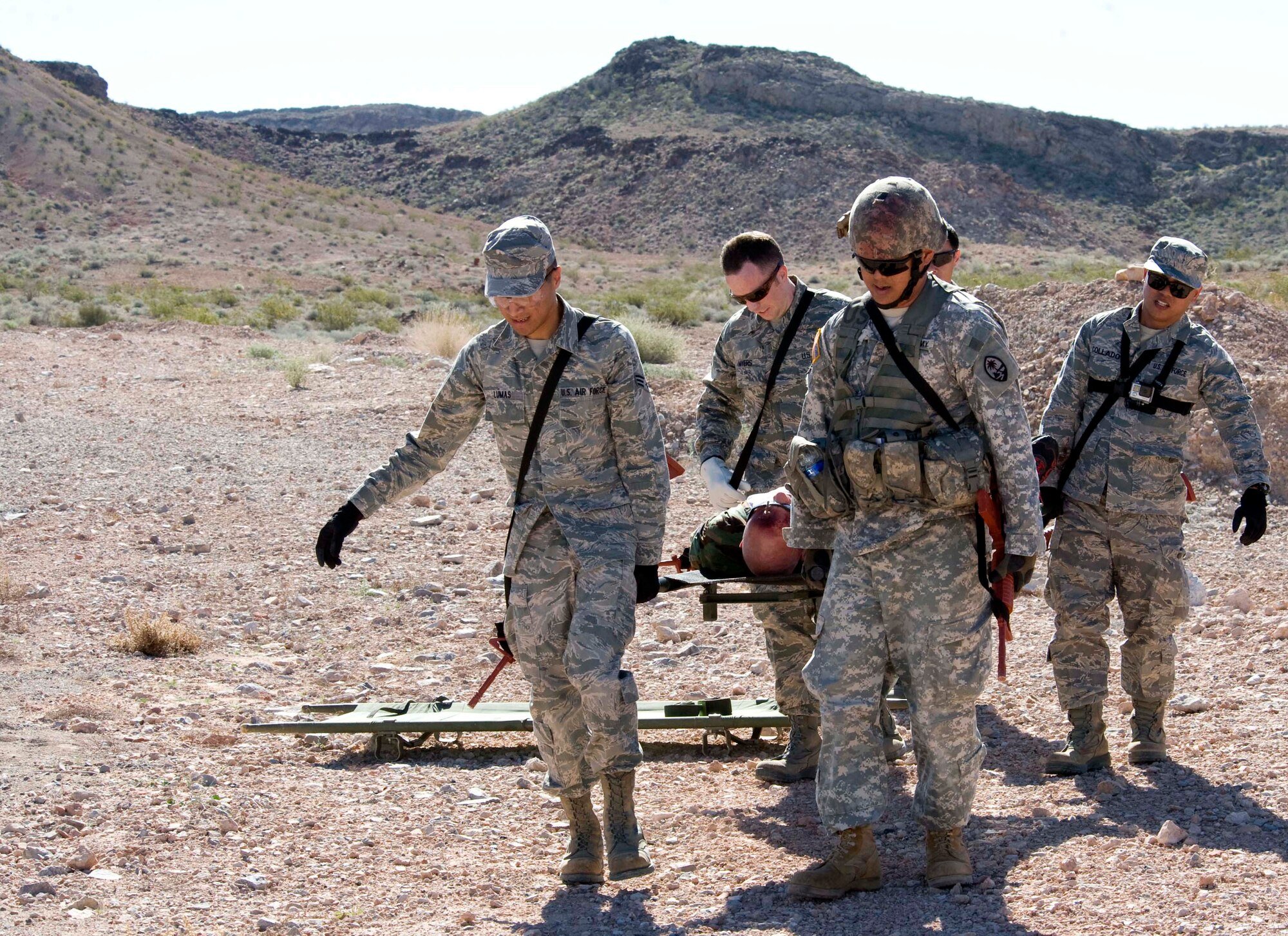 Participants in Operation Joint Medic exercise carry a moulaged patient to a designated area for medical treatment at Nellis Air Force Base, Nev., March 27, 2015. During the exercise, participants had to operate in a simulated hostile environment and extract 27 moulaged patients. (U.S. Air Force photo by Airman 1st Class Rachel Loftis)  