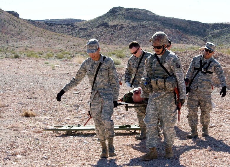 Participants in Operation Joint Medic exercise carry a moulaged patient to a designated area for medical treatment at Nellis Air Force Base, Nev., March 27, 2015. During the exercise, participants had to operate in a simulated hostile environment and extract 27 moulaged patients. (U.S. Air Force photo by Airman 1st Class Rachel Loftis)  