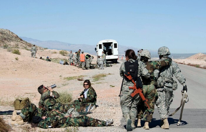 Participants in a joint medical exercise escort a moulaged patient to a designated area for medical treatment during Operation Joint Medic exercise located at Camp Cobra, Nellis Air Force Base, Nev., March 31, 2015. Operation Joint Medic gave  medical personnel the opportunity to treat numerous injuries on simulated casualties. (U.S. Air Force photo by Airman 1st Class Rachel Loftis) 